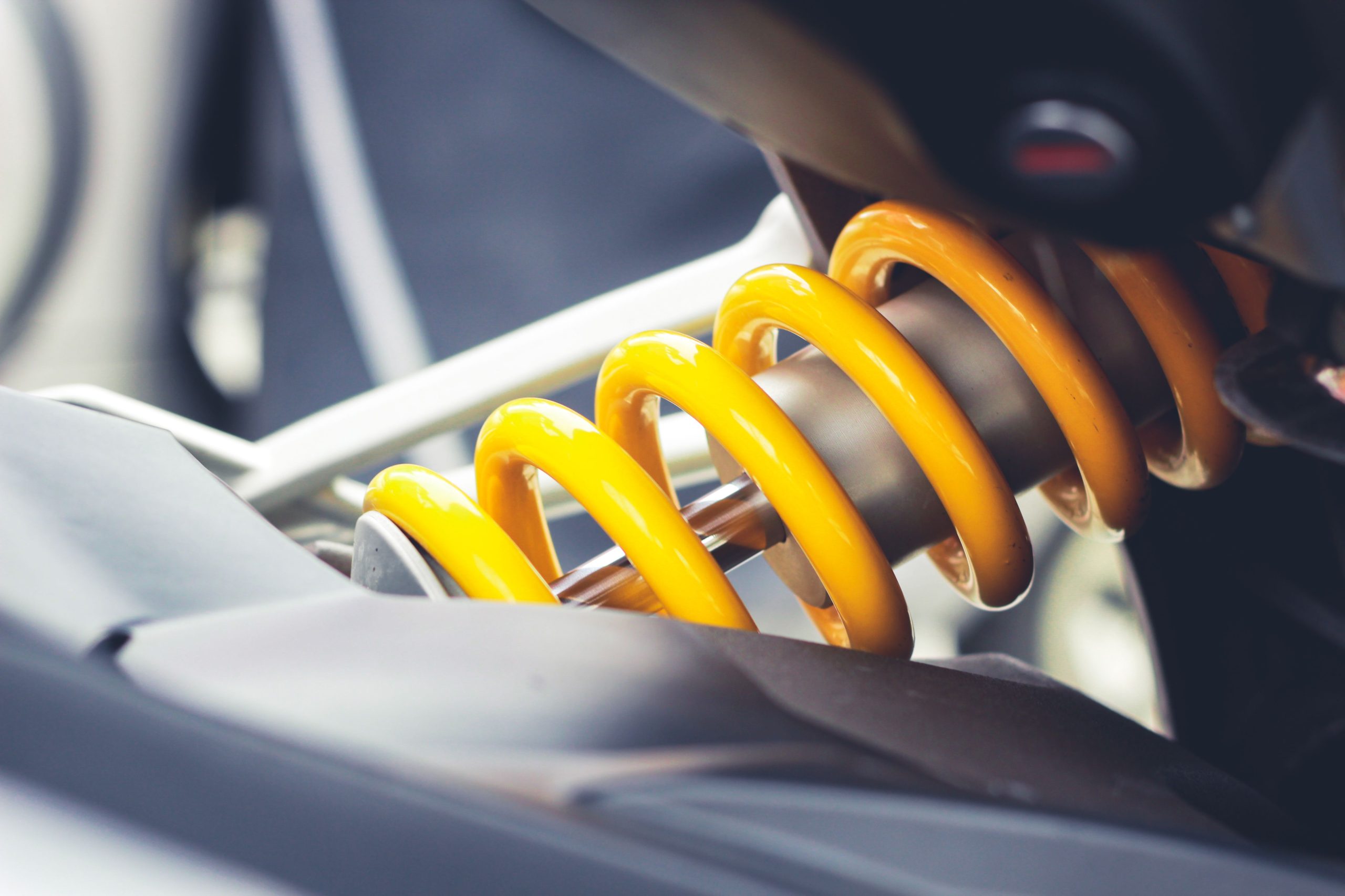 Services Close-up of a vibrant yellow coil spring, showcasing mechanical engineering details.