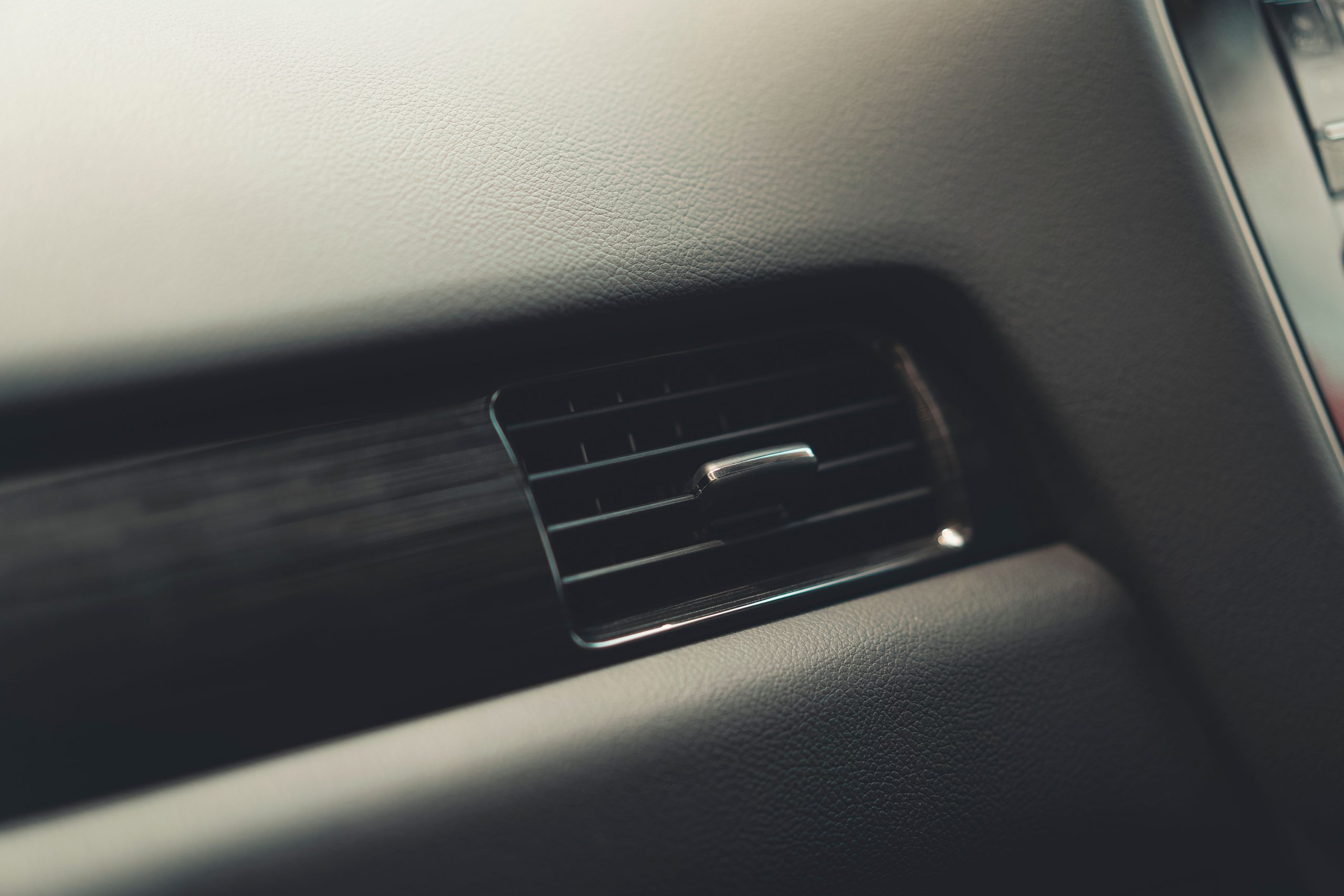 Services Detailed view of a car air vent system, showcasing interior design and texture.